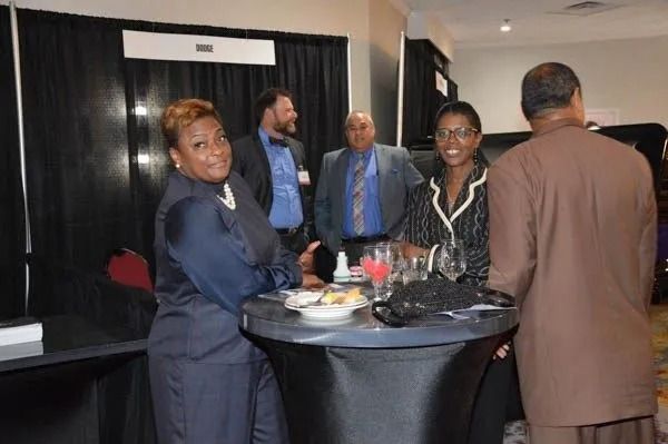 People socializing at a cocktail table in a dimly lit event hall