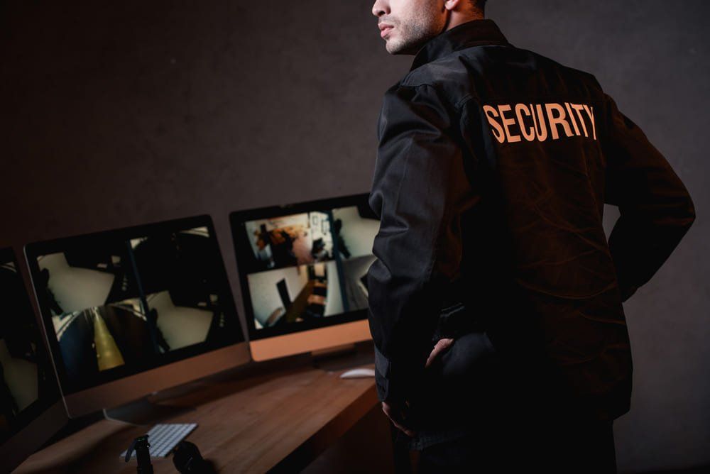 A security guard is standing in front of a computer monitor in Washington DC