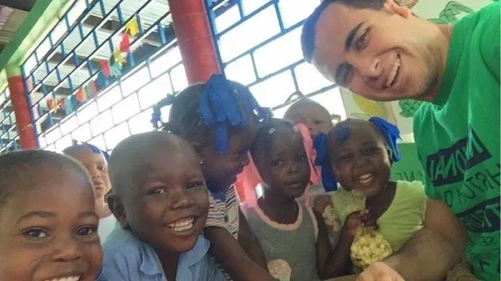 Group selfie with smiling children and an adult in a colorful indoor room