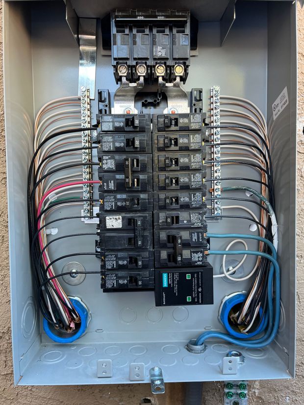 An open electrical service panel showing installed circuit breakers, wiring, and neutral/ground bus bars.