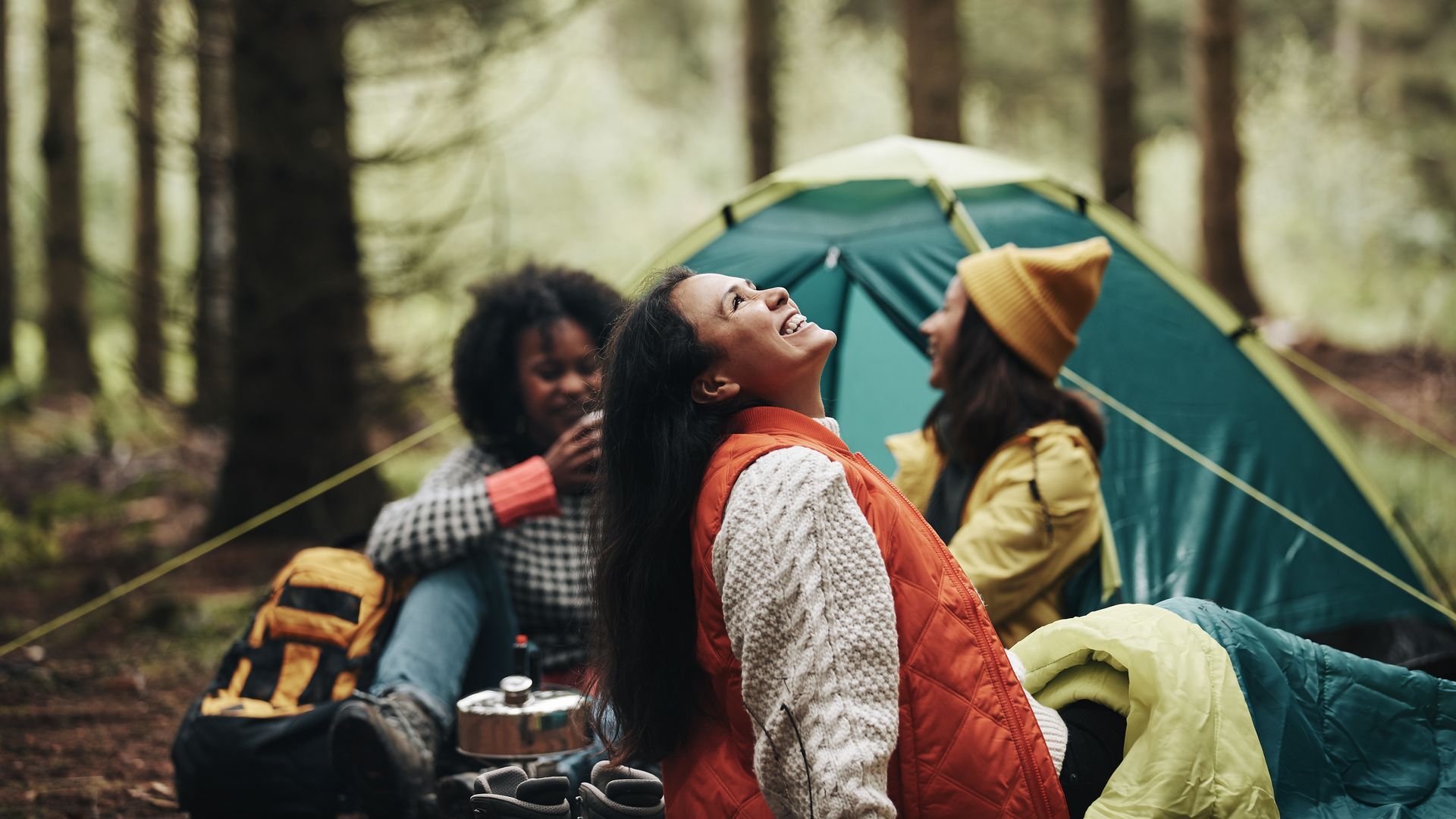 Group of friends enjoying a forest campsite with Camp in a Box rental gear