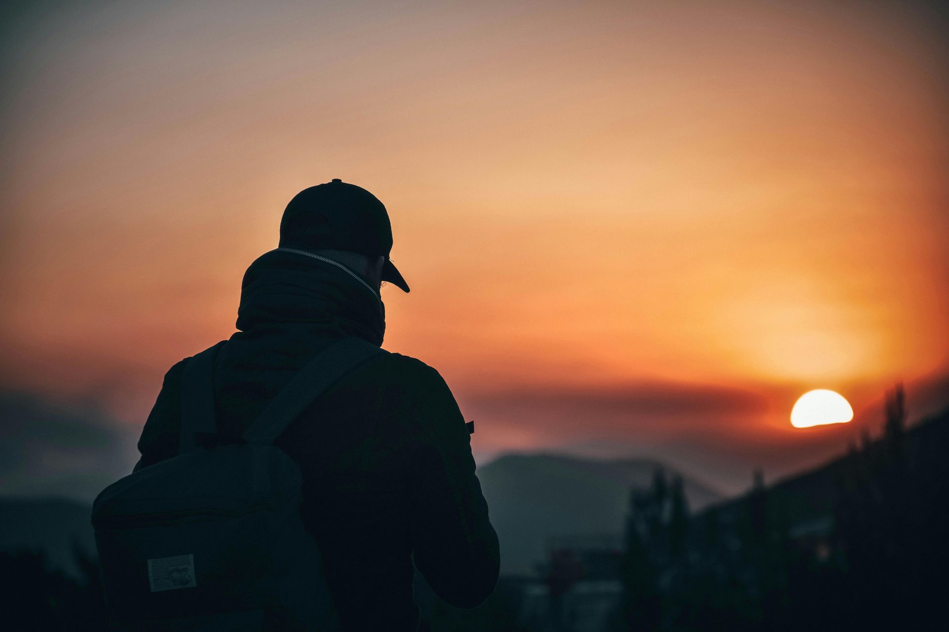 Solo backpacker watching sunset on a nature trip with gear from Camp in a Box