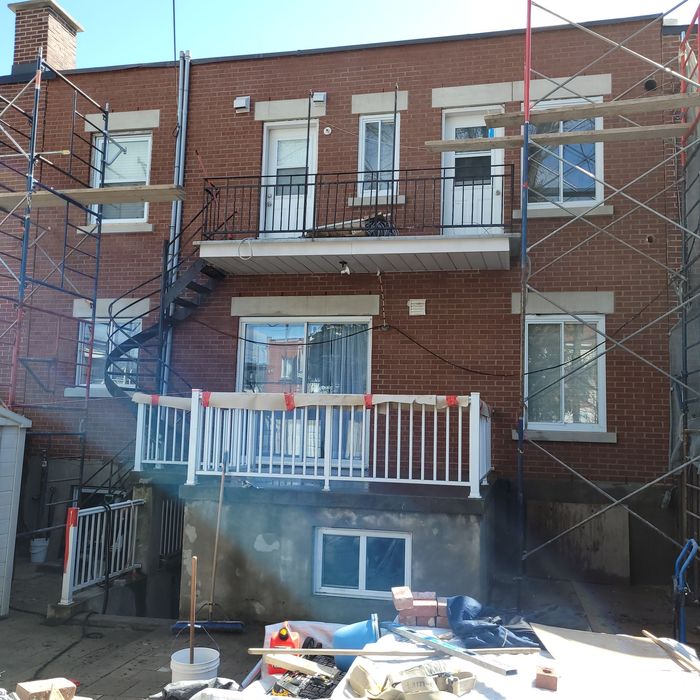 Un bâtiment en briques avec un balcon et un échafaudage autour