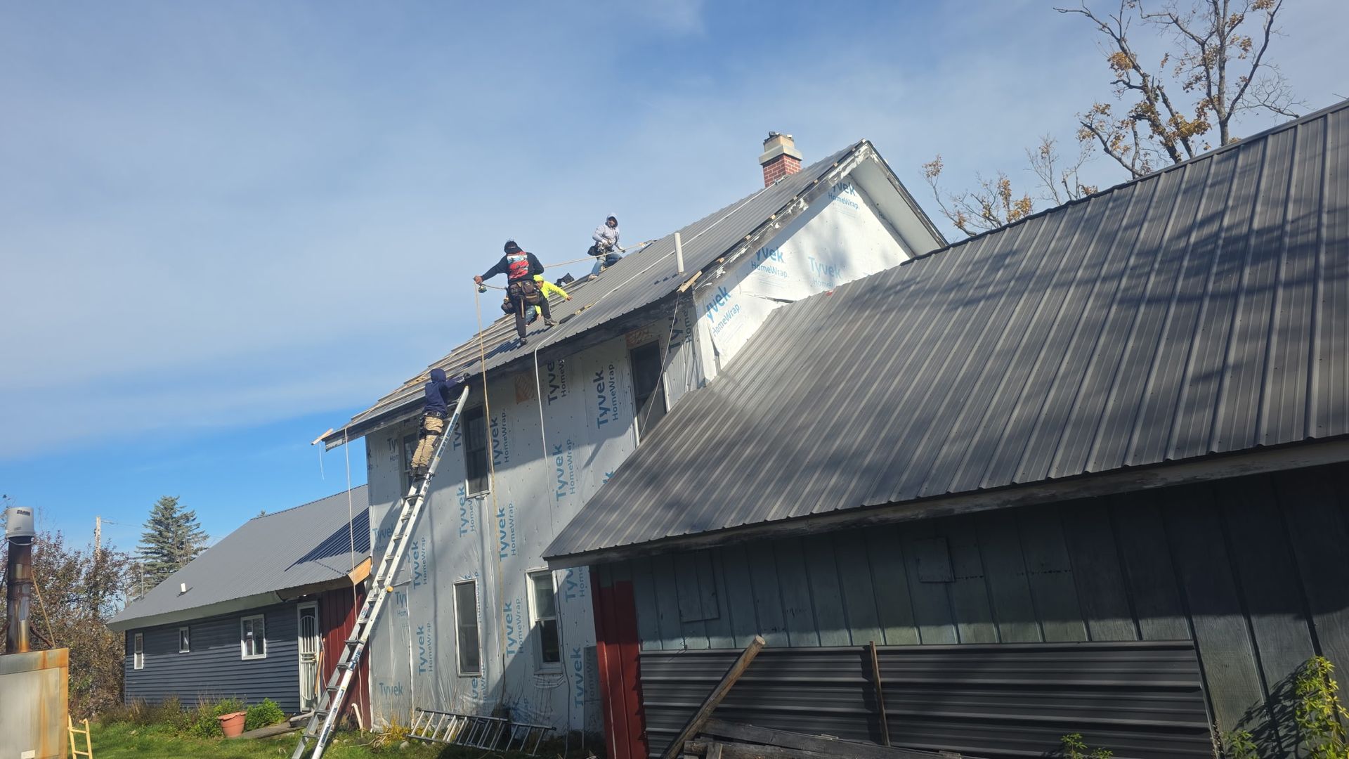 Alpine Brothers Construction team installing a residential metal roof and replacing vinyl siding