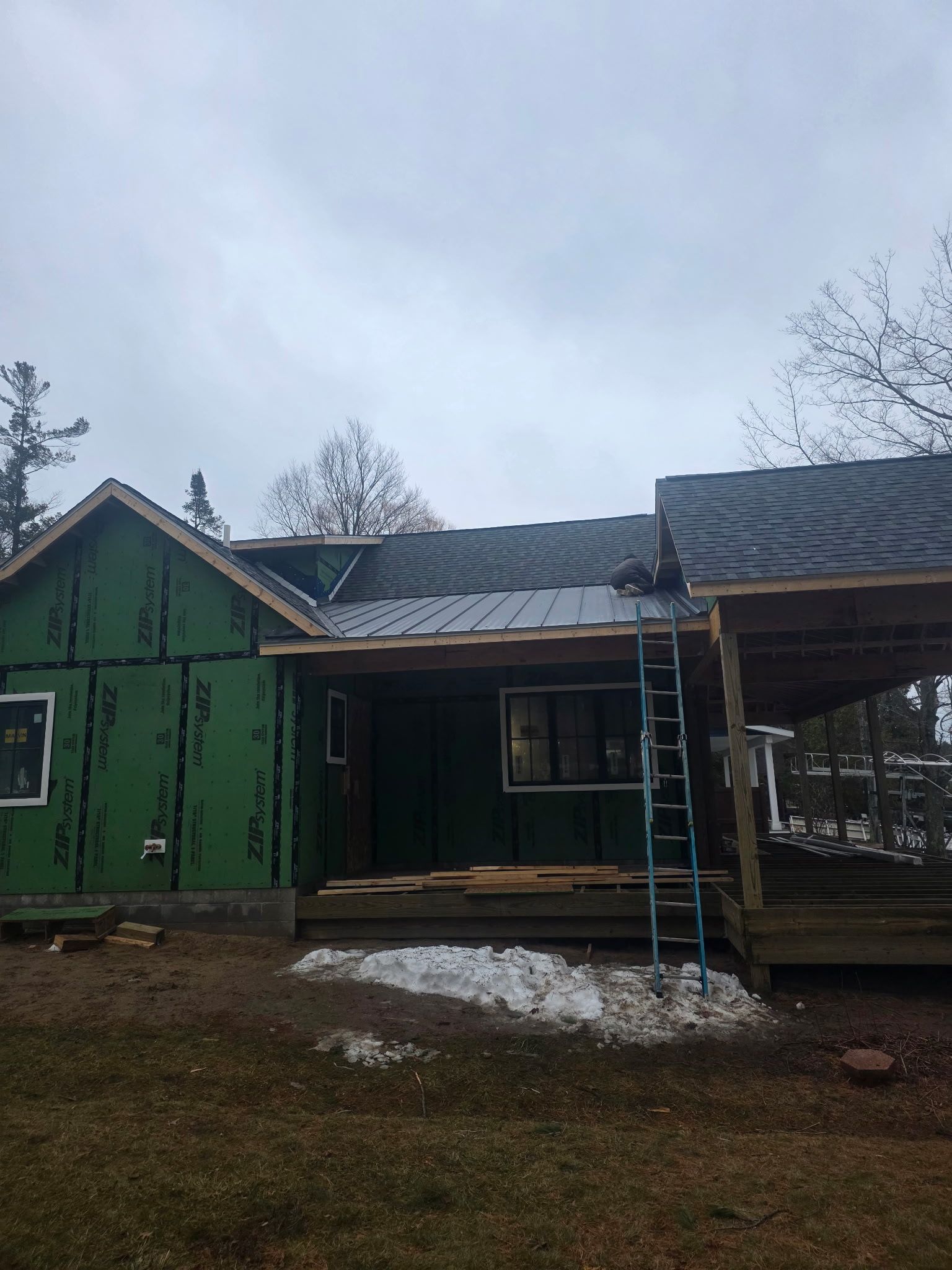 House with siding installation and a roof with asphalt shingles and metal roofing installed