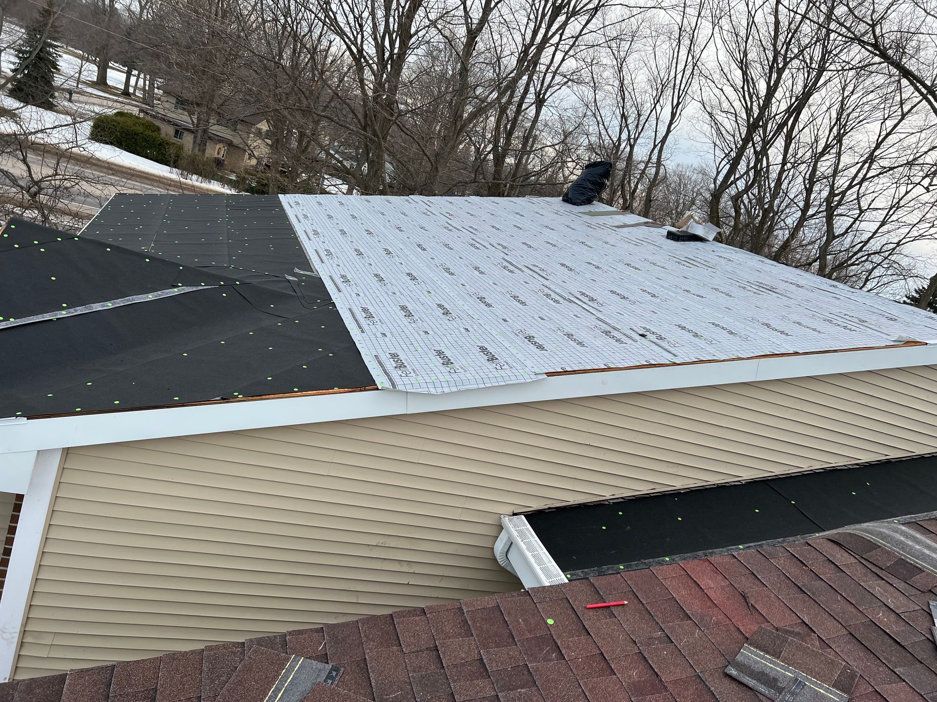Roof replacement in Gaylord, MI showing the installation of waterproof underlayment and drip edge on a residential home.