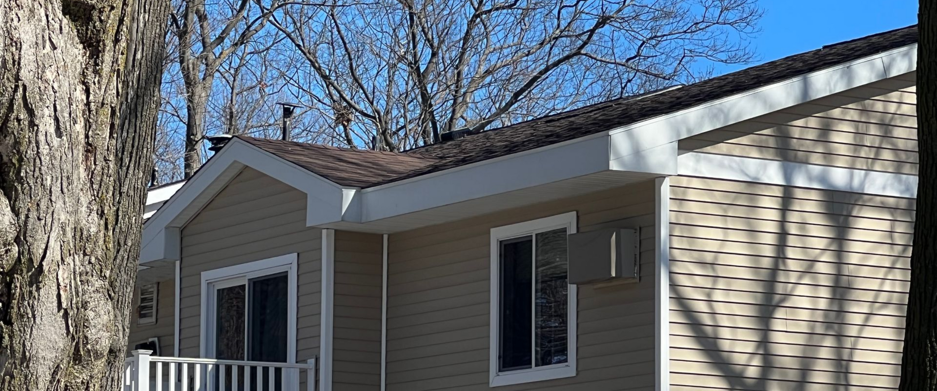 House with tan siding and brown asphalt shingle installation in Gaylord, MI.