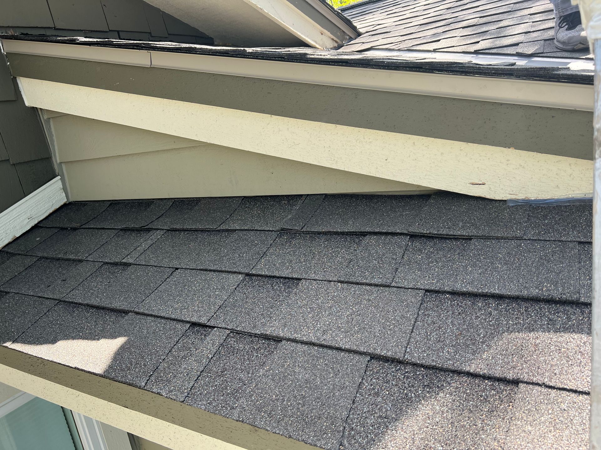 Close up image of a roof with new dark grey shingle installation by Alpine Brothers Construction