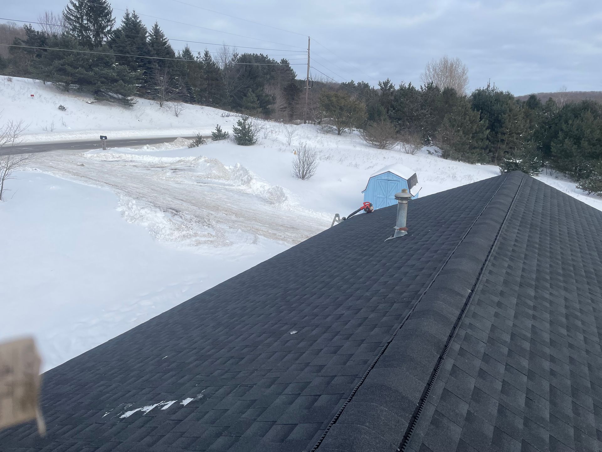Closeup image of top of residential roof with new shingle installation.
