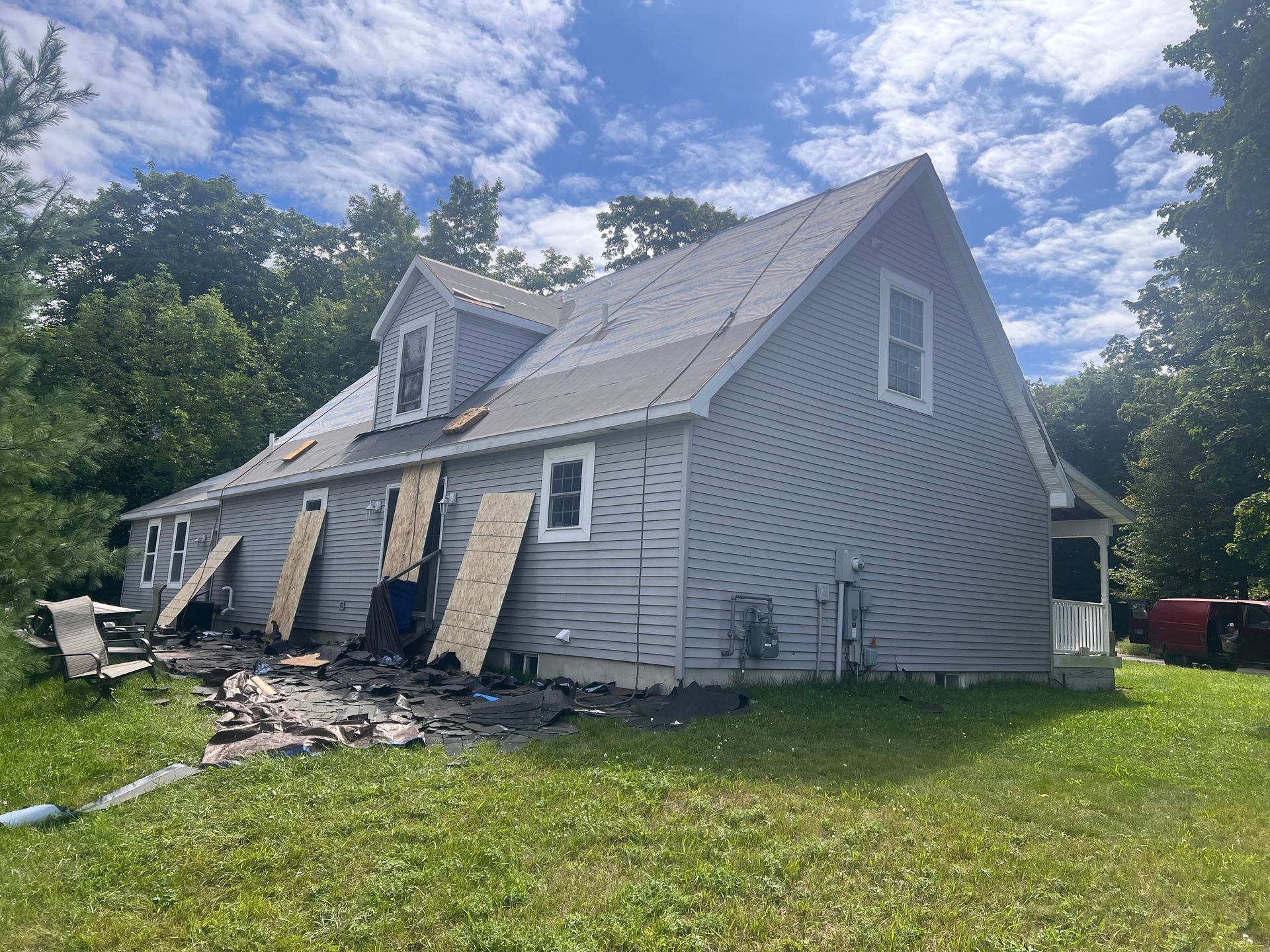 A gray, two-story house with a roof replacement by Alpine Brothers Construction.