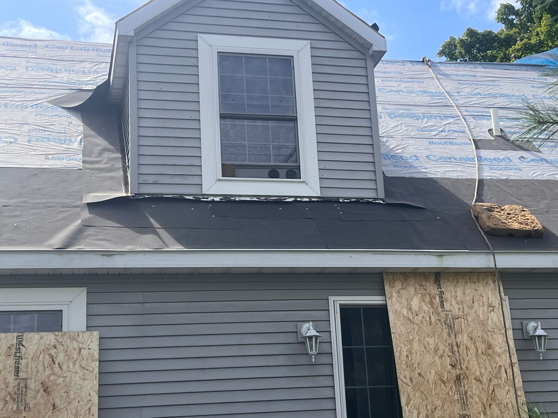 Closeup image of a two-story home with a underlayment for a residential roof replacement in Gaylord, MI.