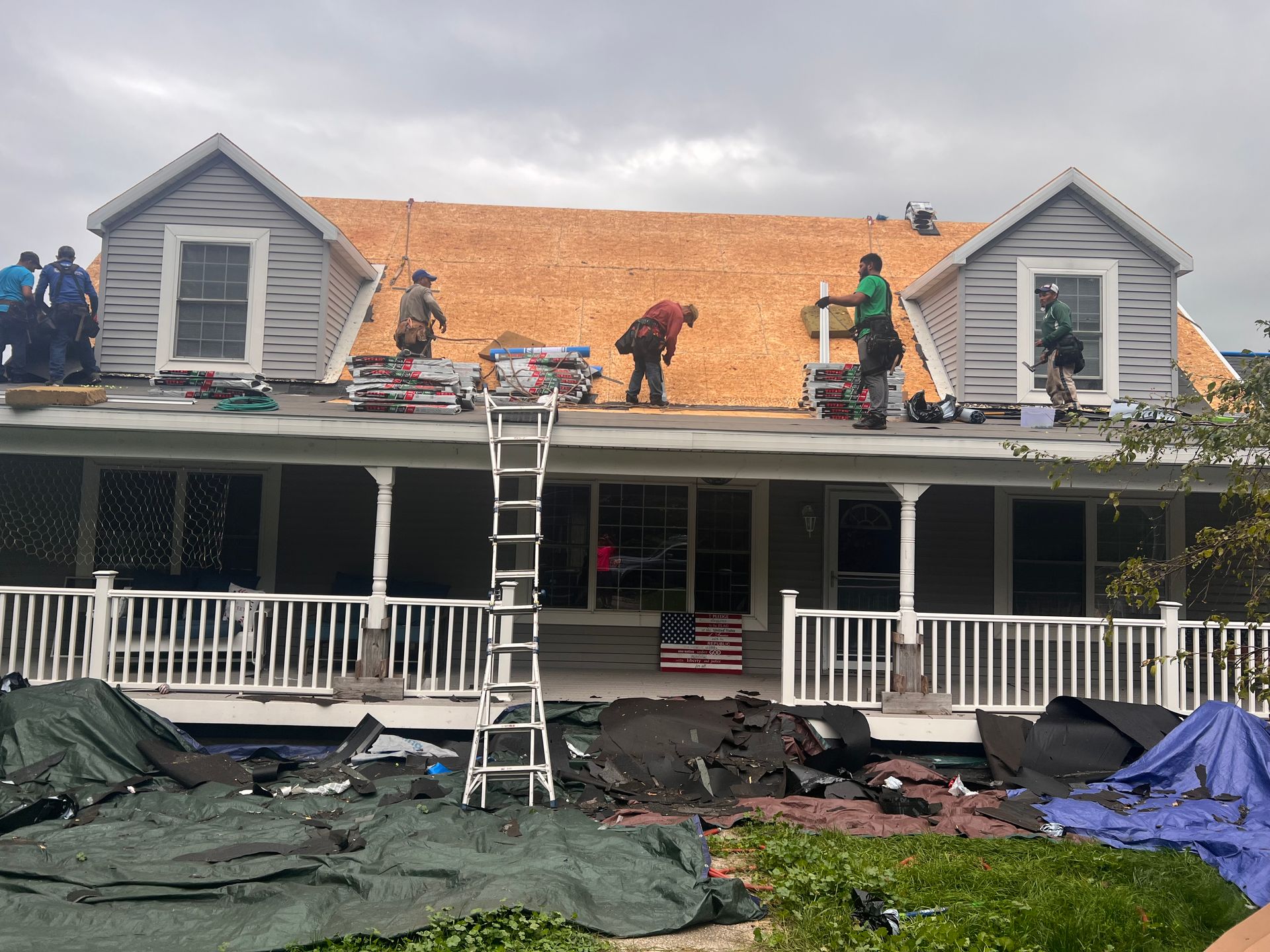 Alpine Brothers Construction team working on a two-story home's asphalt shingle roof replacement in Gaylord.