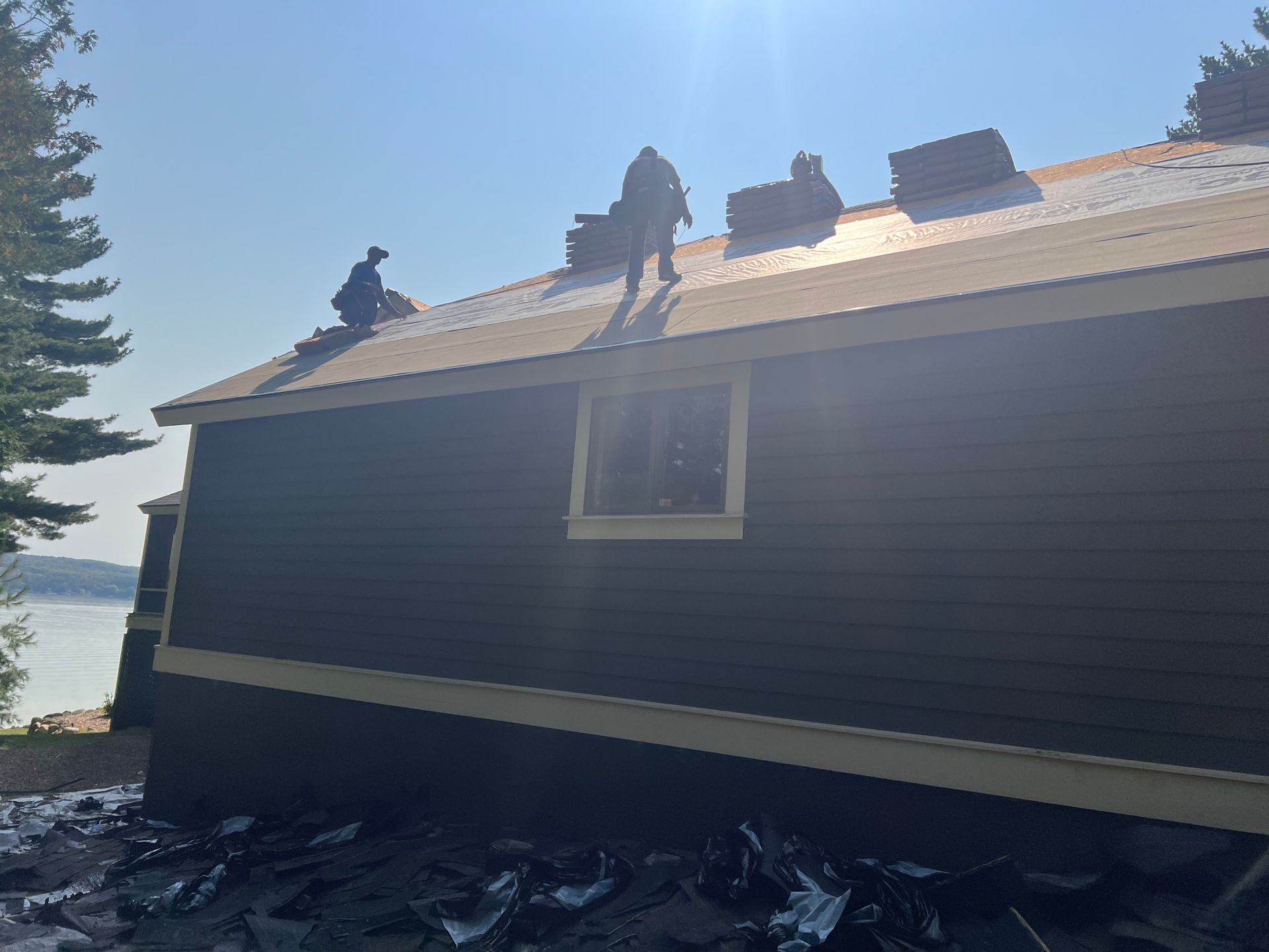 Alpine Brothers Construction crew performing siding installation and slope roofing on a residential project in Gaylord, MI.