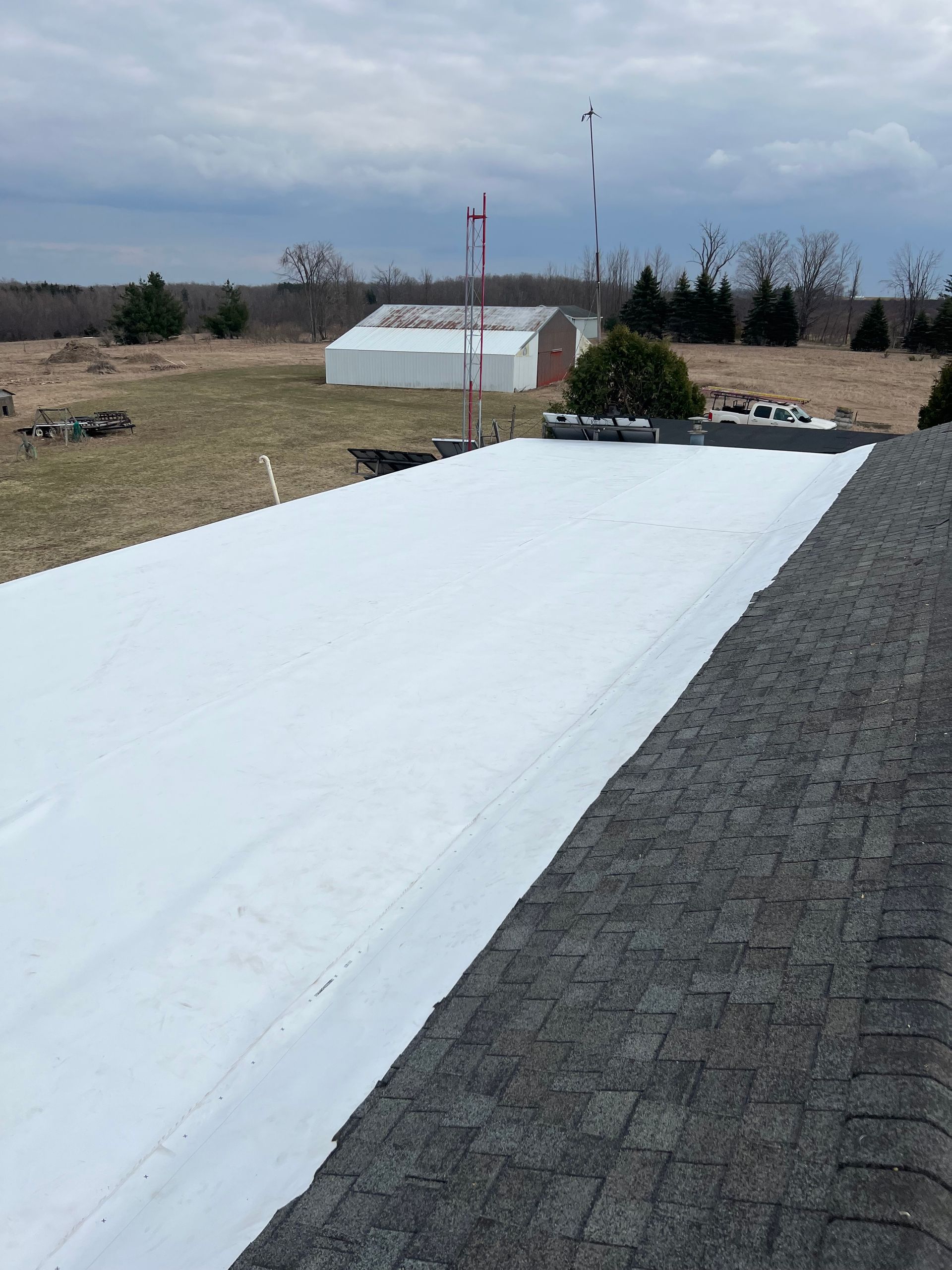 Aerial view of a commercial asphalt shingle roofing installation in Gaylord, MI