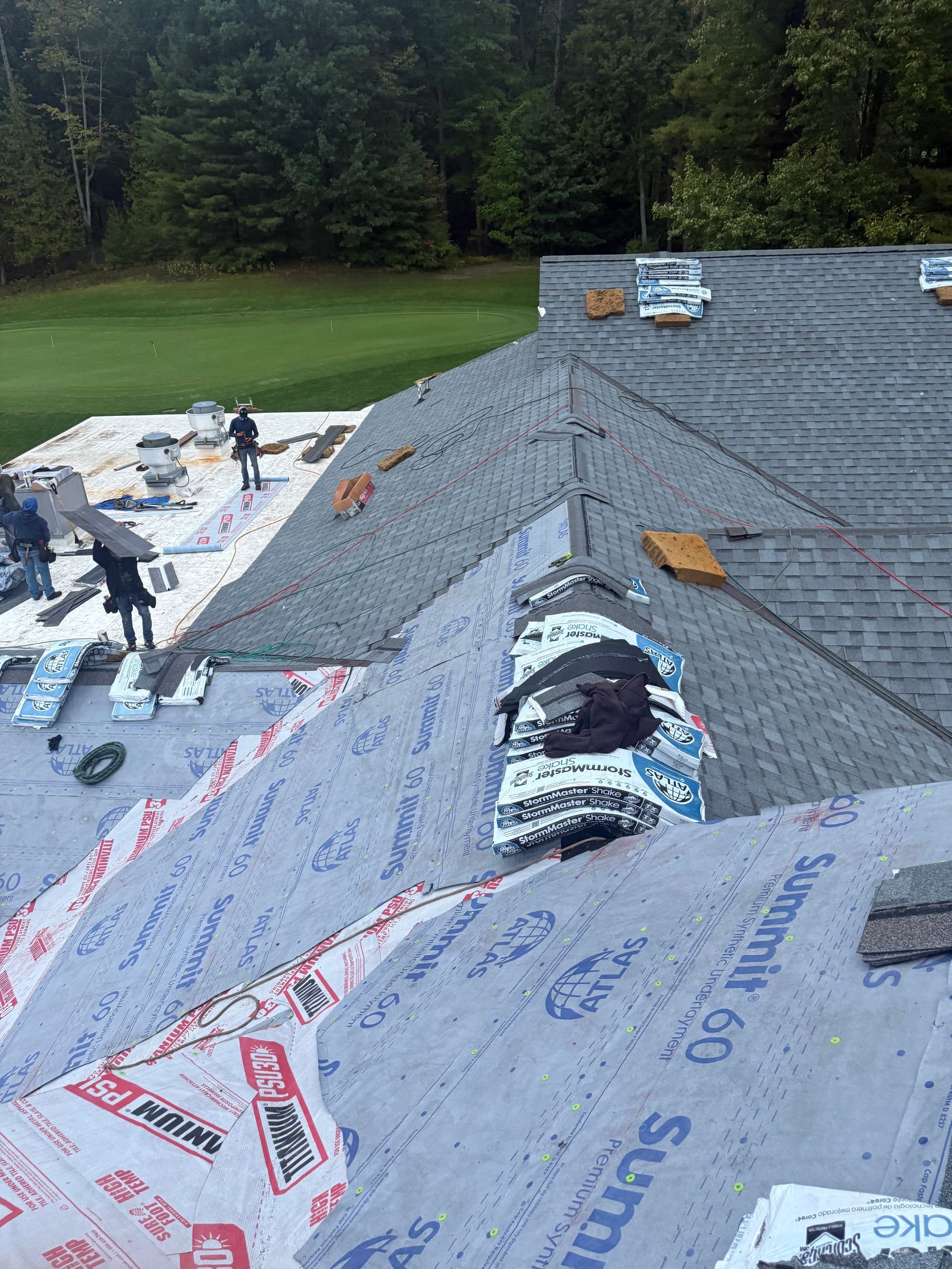Alpine Brothers Construction team working on an asphalt shingle roof installation