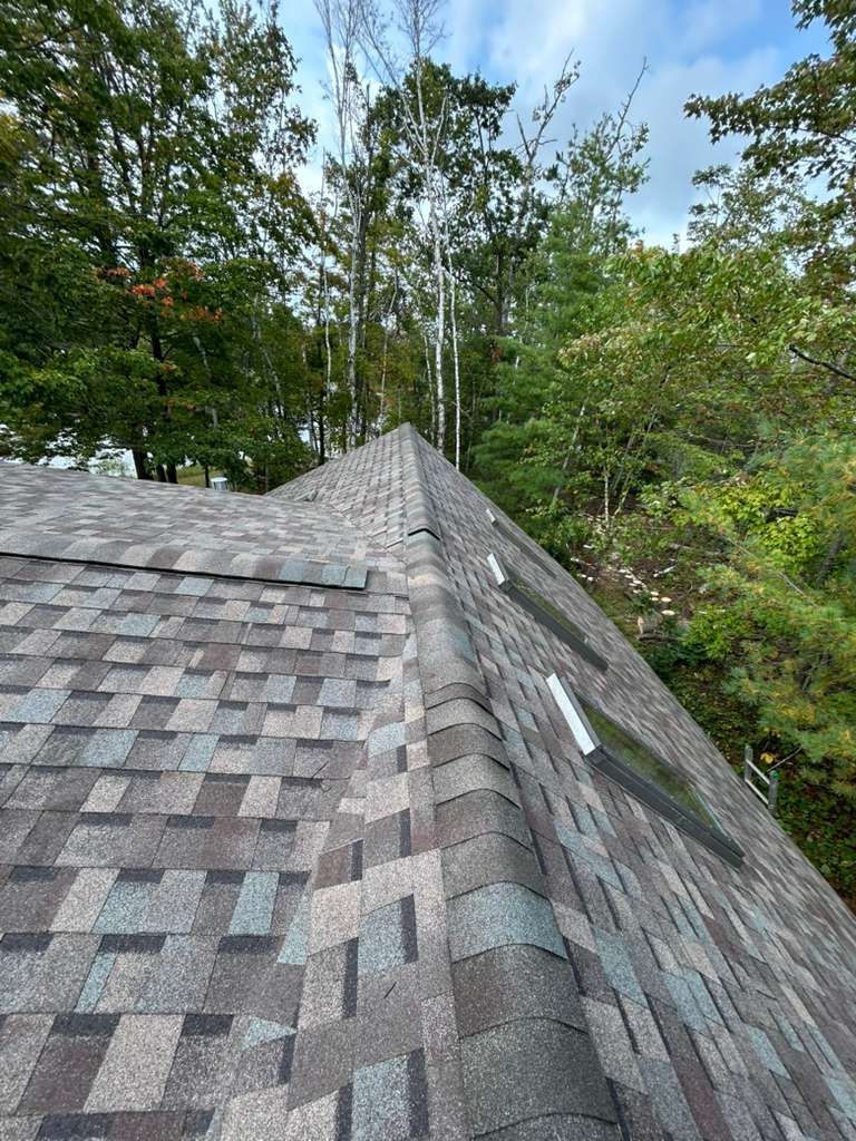 Residential building with asphalt shingle installation and skylight window installation in Gaylord, MI