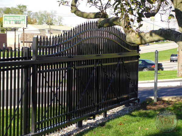 A black sliding gate is open in front of a house.