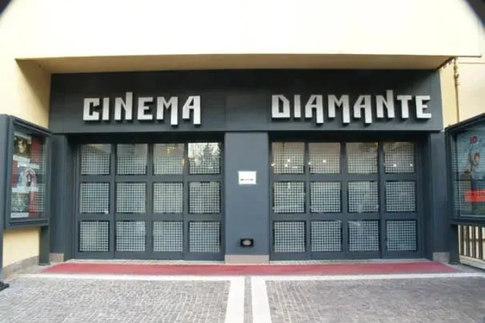 Ingresso del cinema chiuso con porte nere e insegna con la scritta 