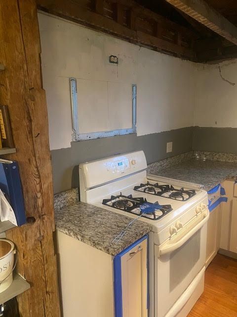 A kitchen with a stove top oven and granite counter tops.