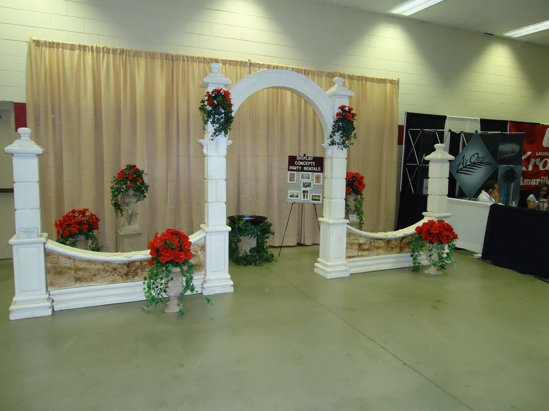 A circular arch made of balloons and flowers in a garden