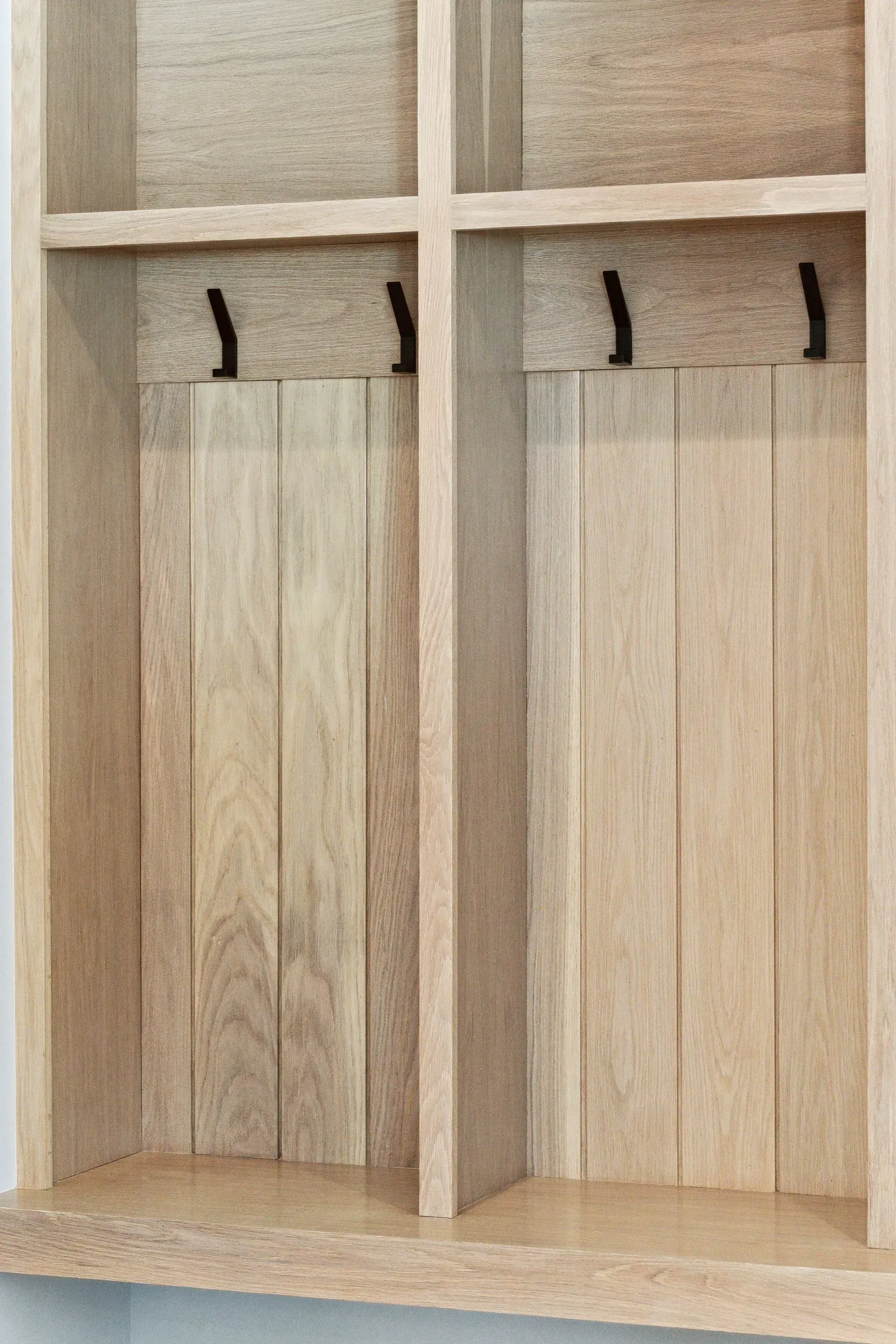 Wooden built-in wardrobe with four compartments and hanging hooks inside two open sections