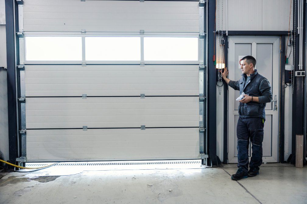 A person wearing an overall checking a garage door