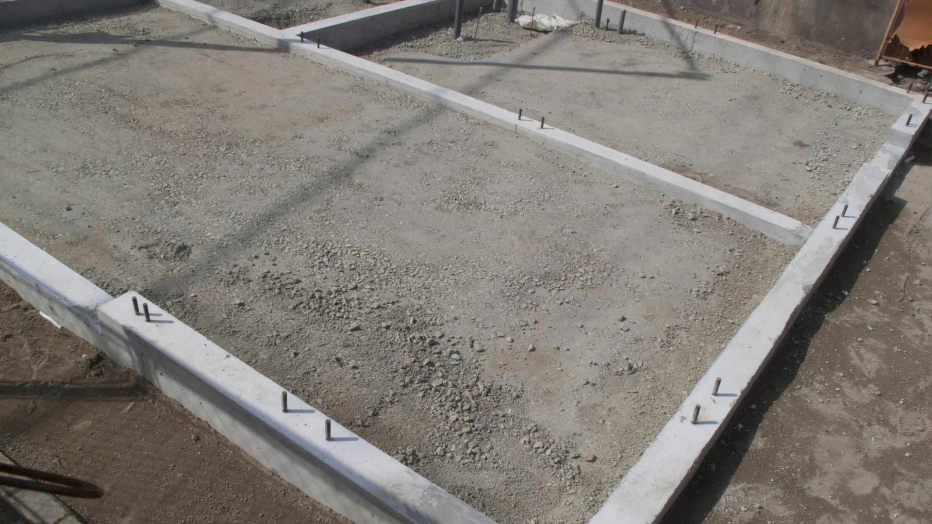 Concrete footing form with wet cement in a rectangular construction frame