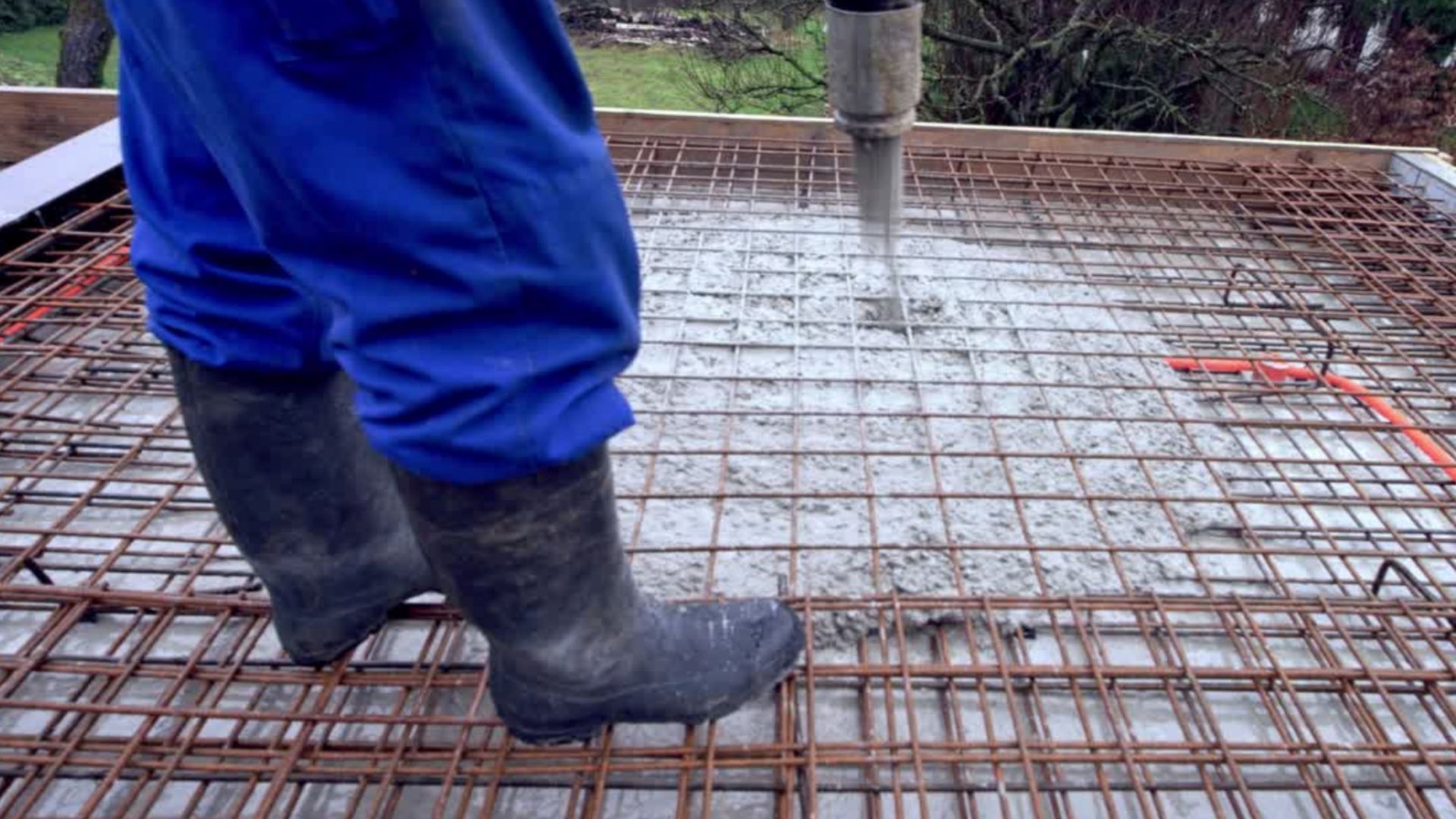 Man with blue pants pumping concrete into house foundations in Rochdale. Concrete supplied by PureMix Concrete Rochdale.