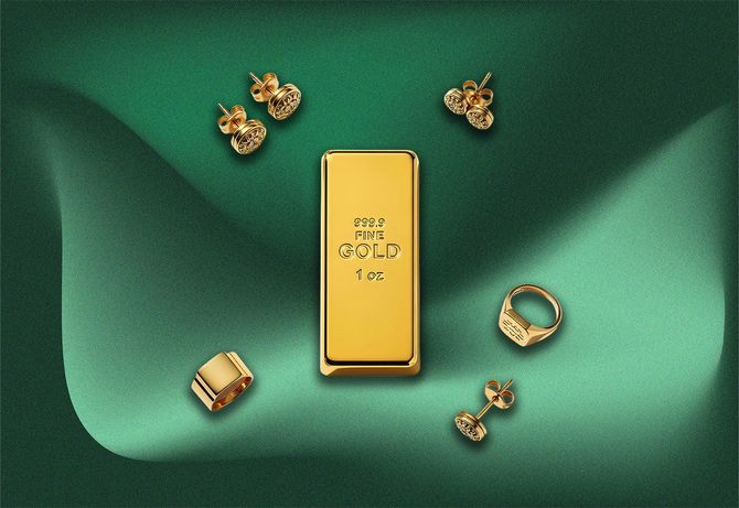 Gold bar surrounded by gold jewelry on a draped green background.