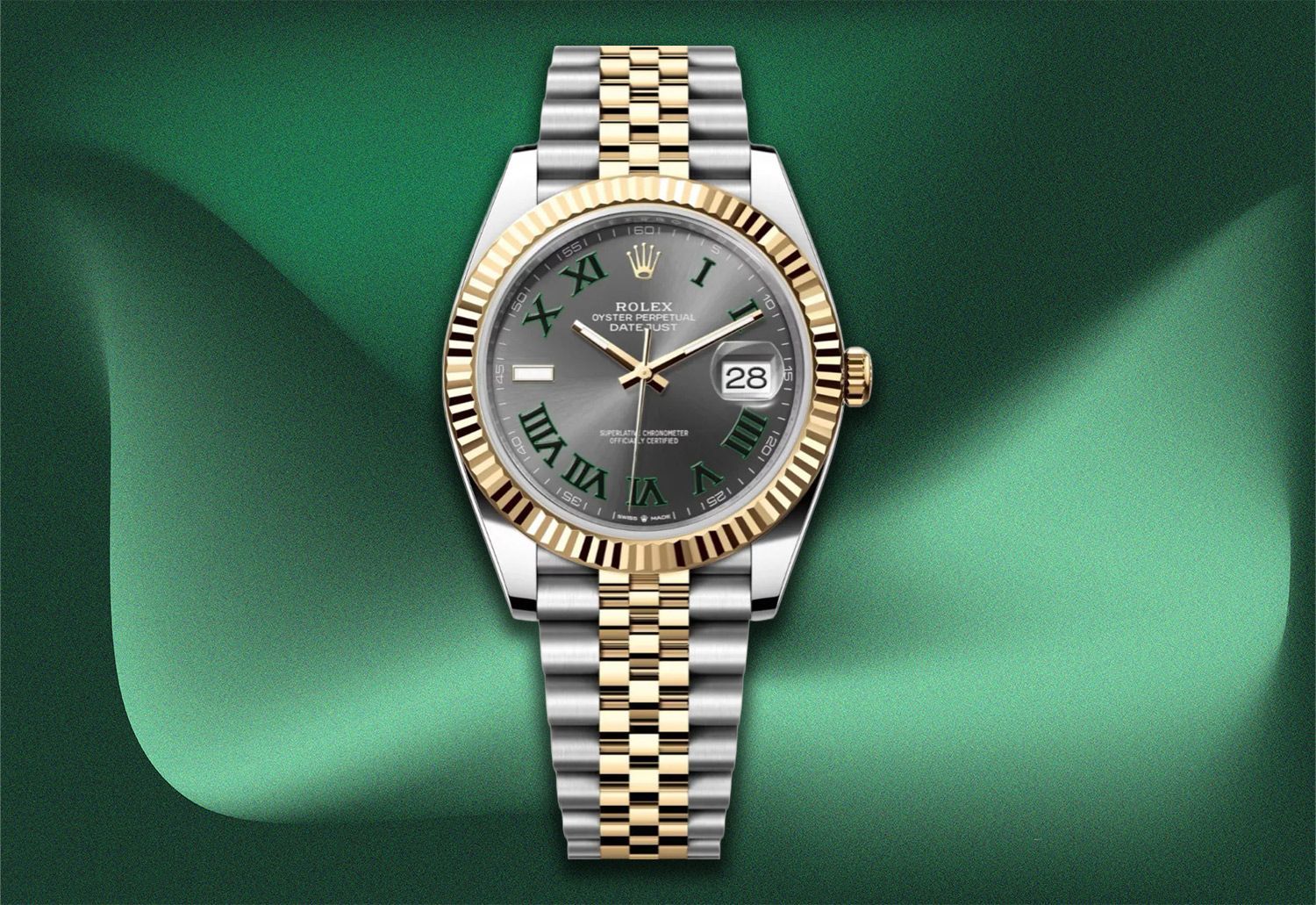 Rolex Datejust watch with a gold and silver band, set against a green fabric background.
