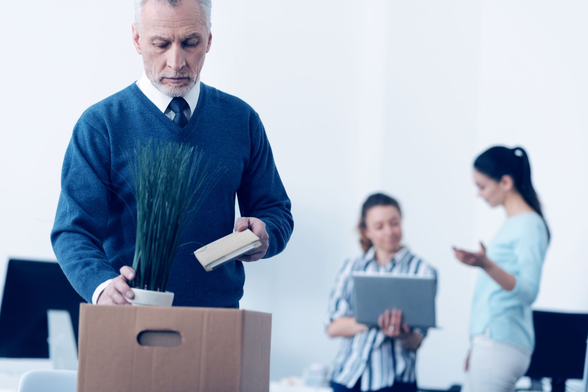 Man packing belongings in box; wrongful termination or discrimination claims.