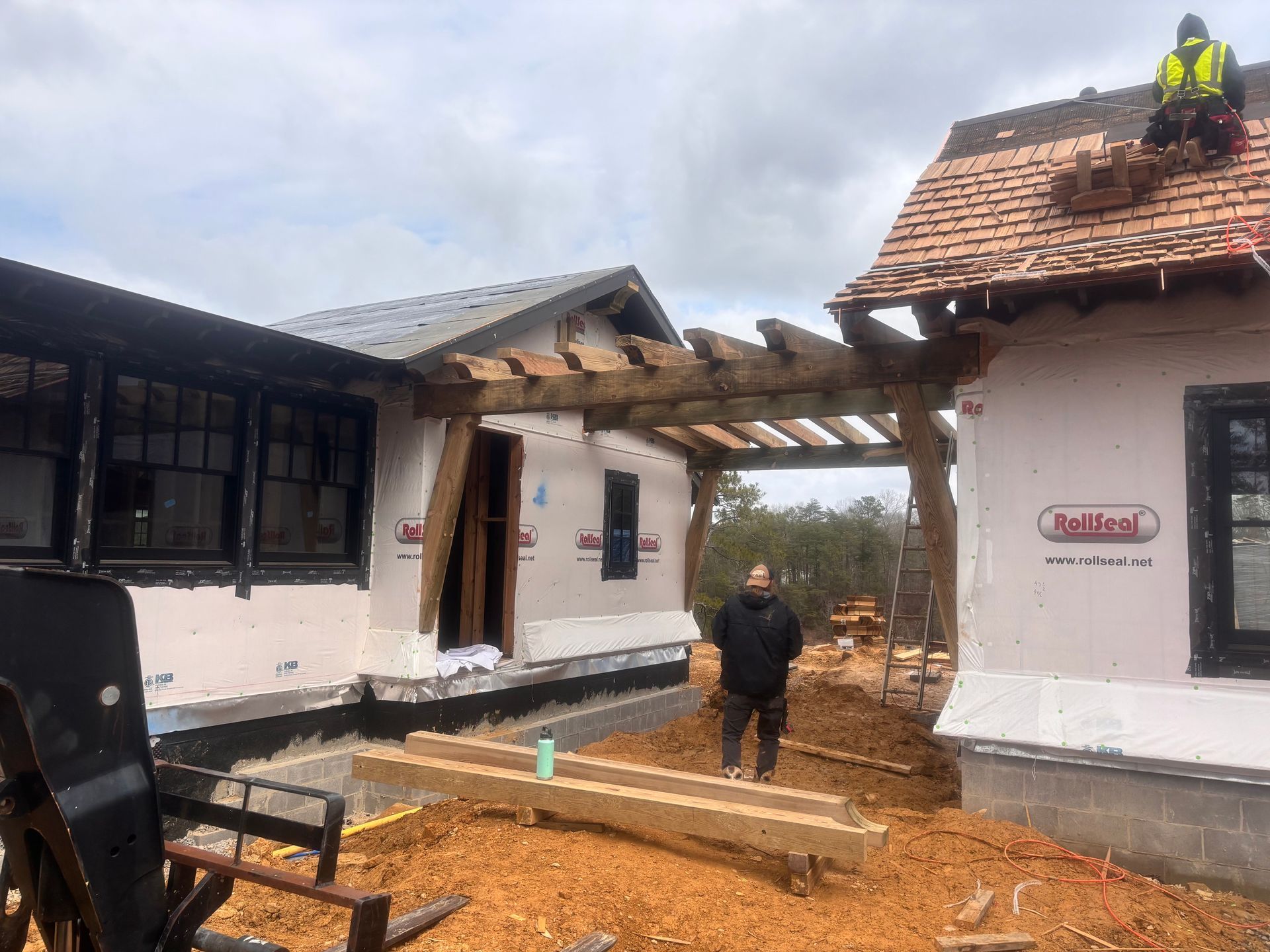 Two workers on a partially rebuilt house with damaged roof and debris in the courtyard