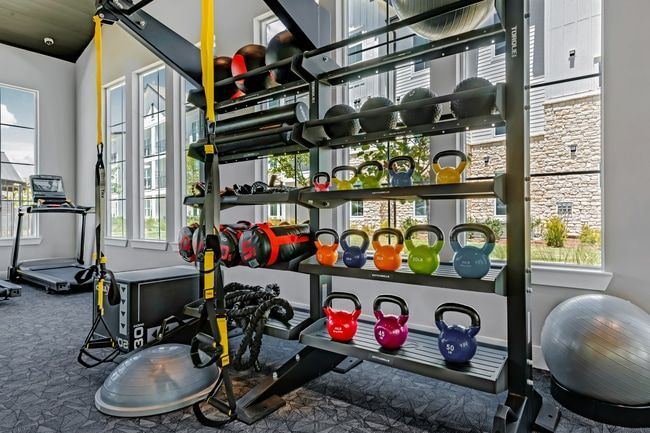 A large gym with a lot of treadmills and exercise equipment at Atlas Bluewood in Celina, TX.