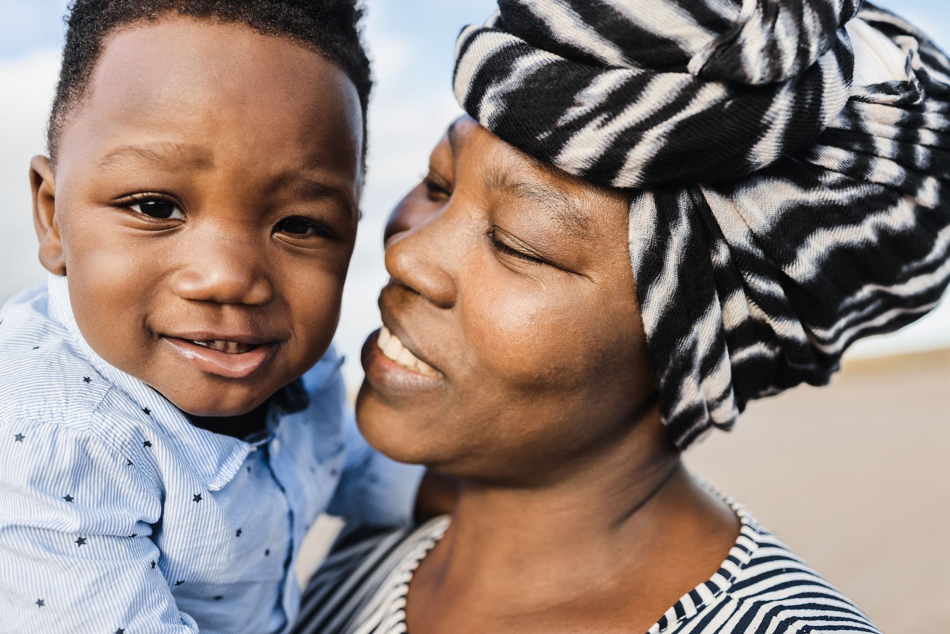 Mãe e filho africanos sorrindo, segurança e dignidade para famílias imigrantes e refugiadas