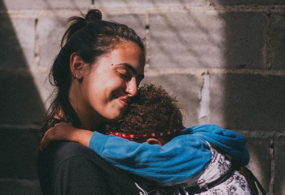 Mulher feliz segurando o filho, direitos da mulher e da criança, segurança contra violência doméstica e de gênero