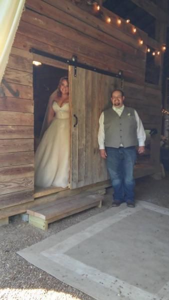 Wedding couple posing in a rustic wooden cabin doorway under string lights