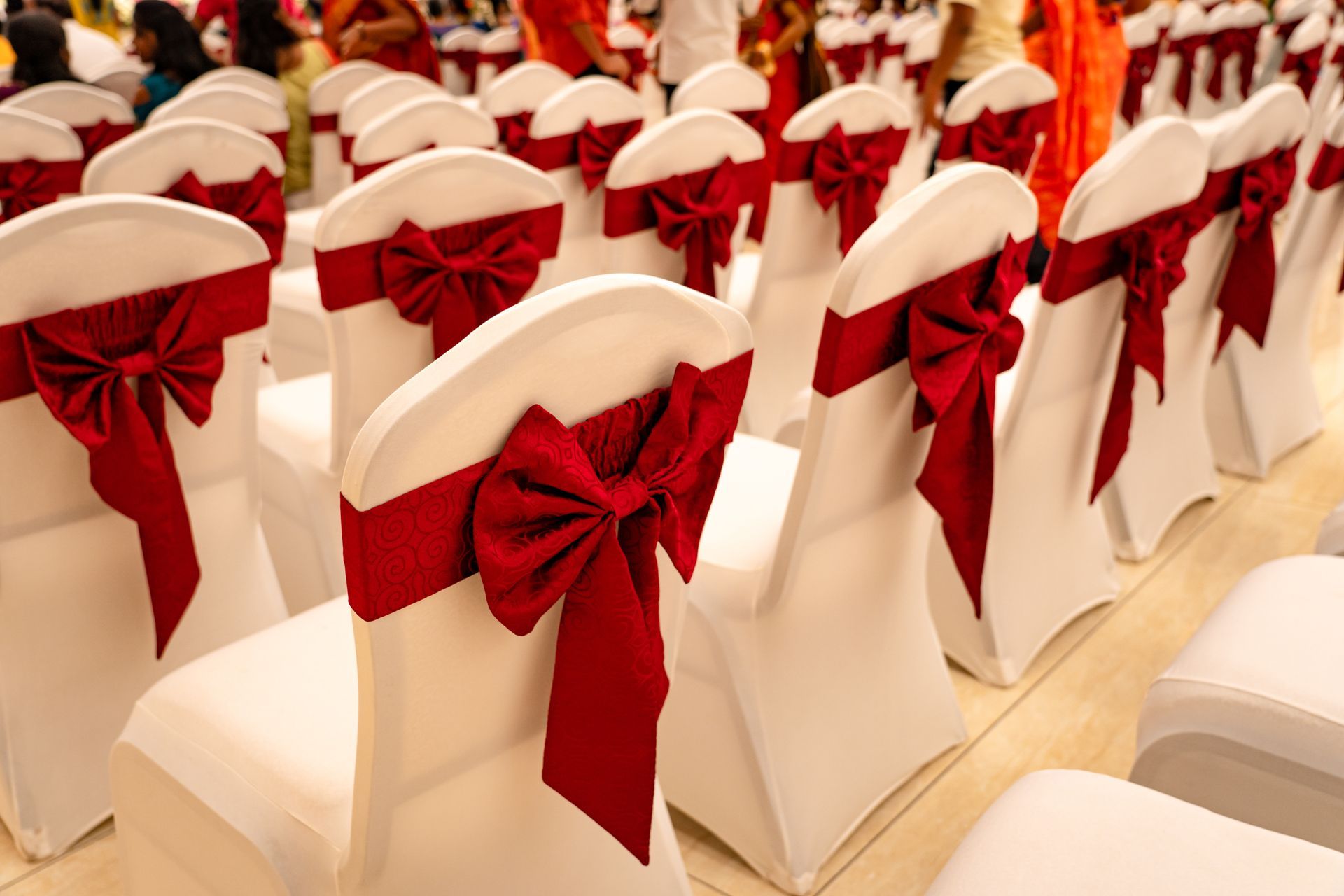 White chairs with red bows, arranged in rows for an event.
