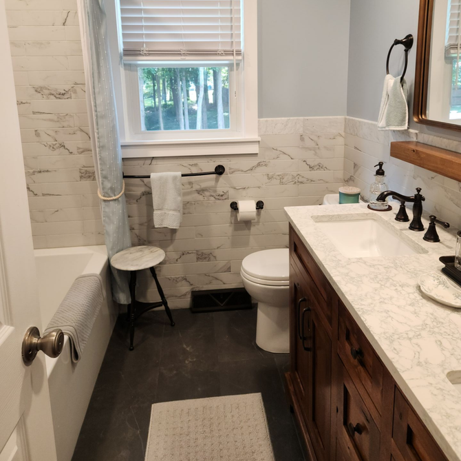 Bright bathroom with double vanity, two mirrors, wall lights, and a toilet on the right.