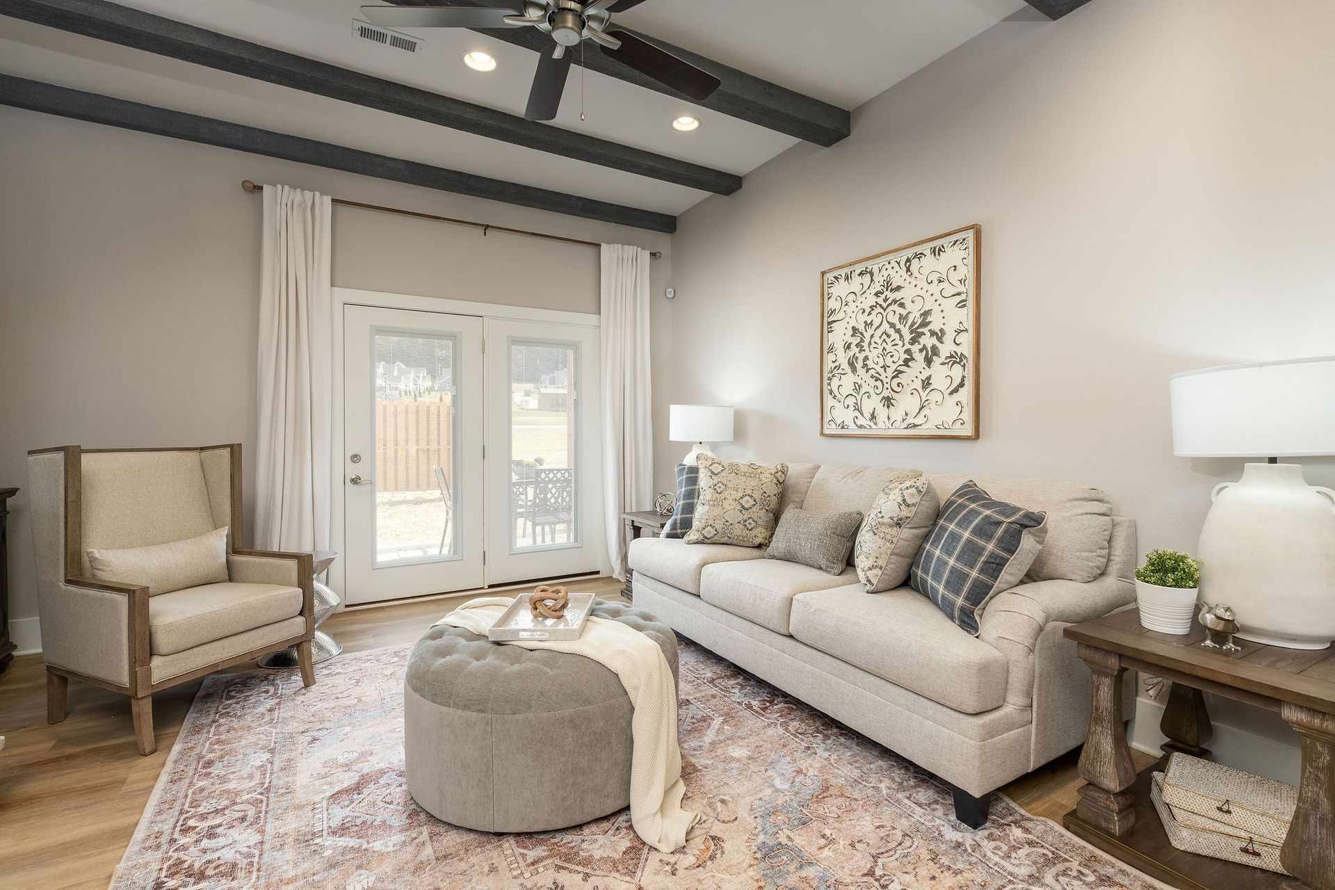 A living room with a couch , chair , ottoman and ceiling fan. The Reserve at Boones Creek, Jonesborough, TN.