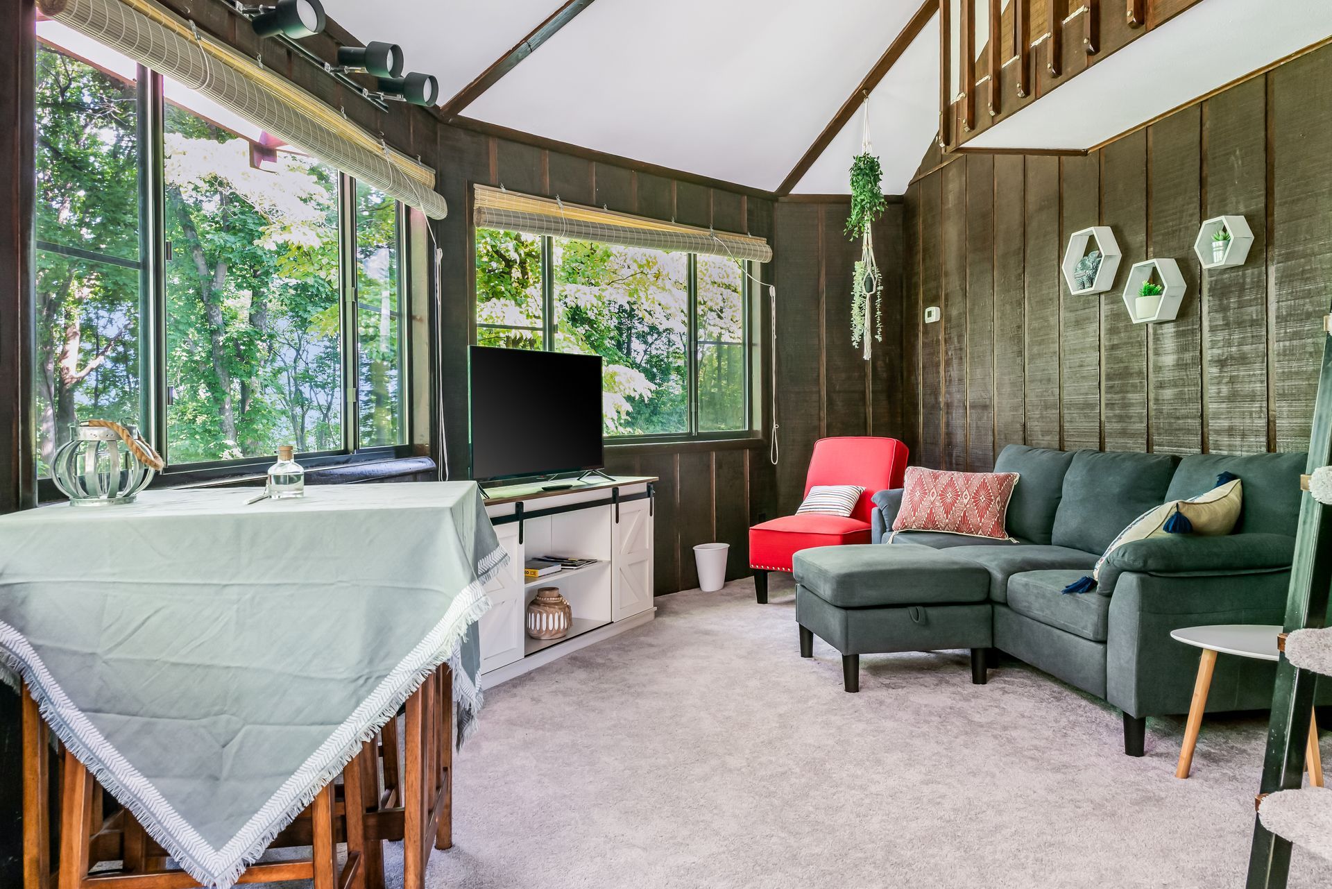 A living room with a couch , chair , table and television.