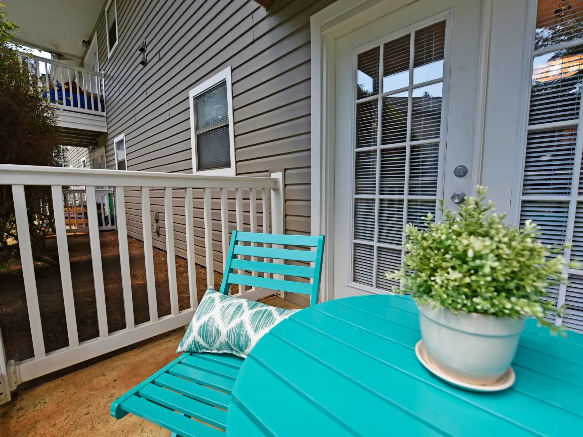 Apartment patio with a blue table and chairs and a potted plant West Knoxville, TN