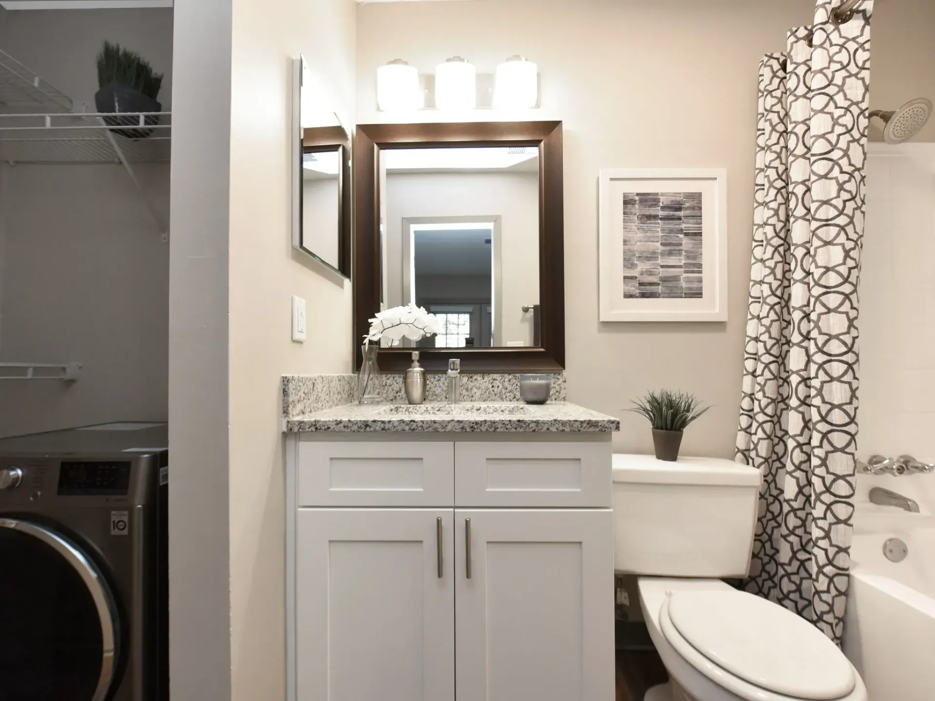A fully furnished modern bathroom with a toilet , sink , mirror and shower curtain West Knoxville, TN