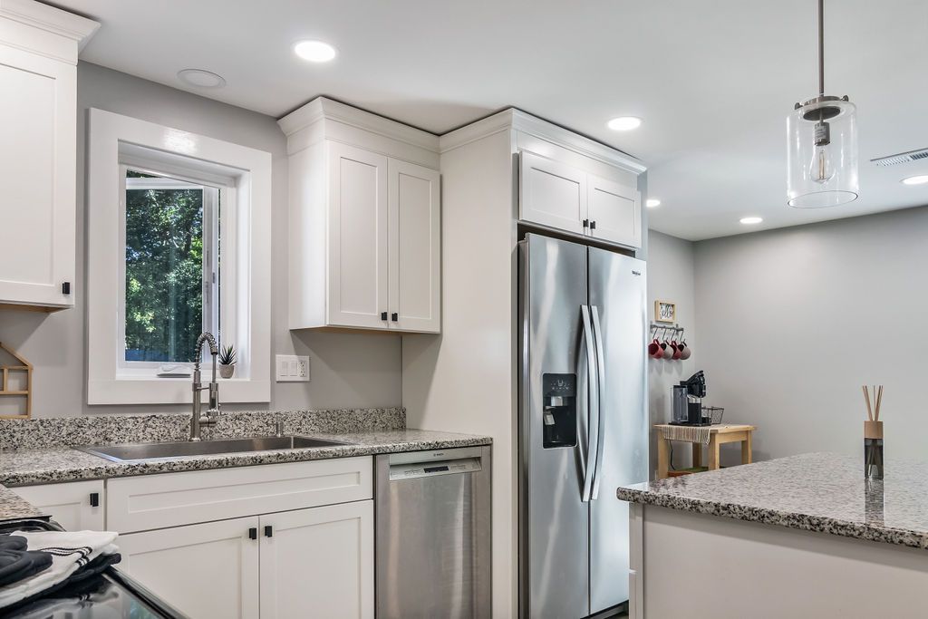 A kitchen with white cabinets , stainless steel appliances and granite counter tops. Mystic, CT Gumball Properties.