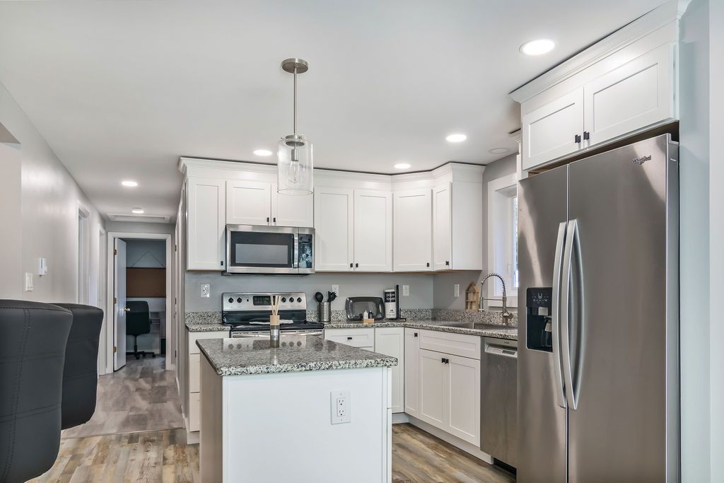 A kitchen with white cabinets and stainless steel appliances, Mystic, CT.