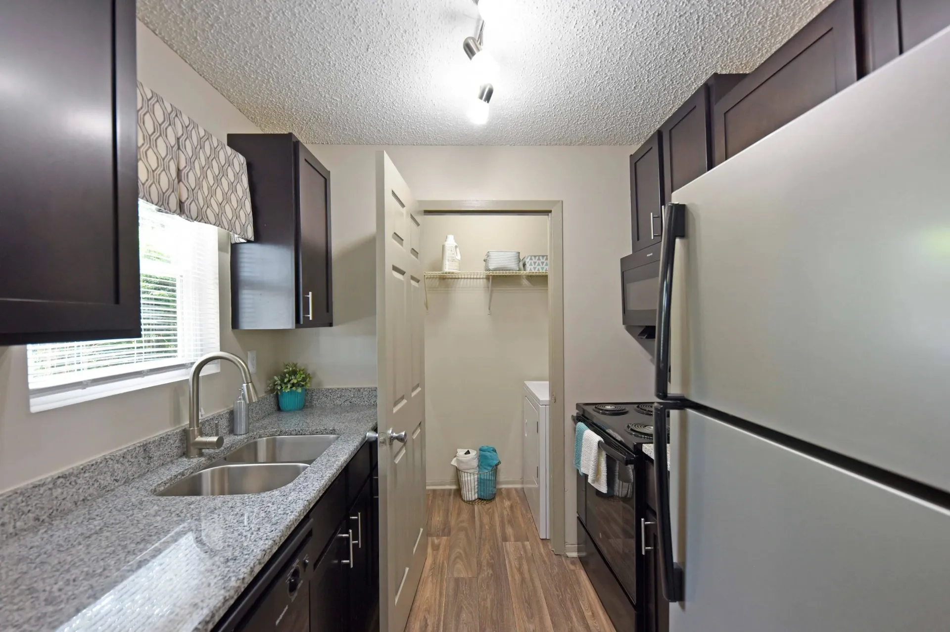 A modern fully furnished West Knoxville, TN apartment kitchen with a sink , refrigerator, stove and dishwasher 