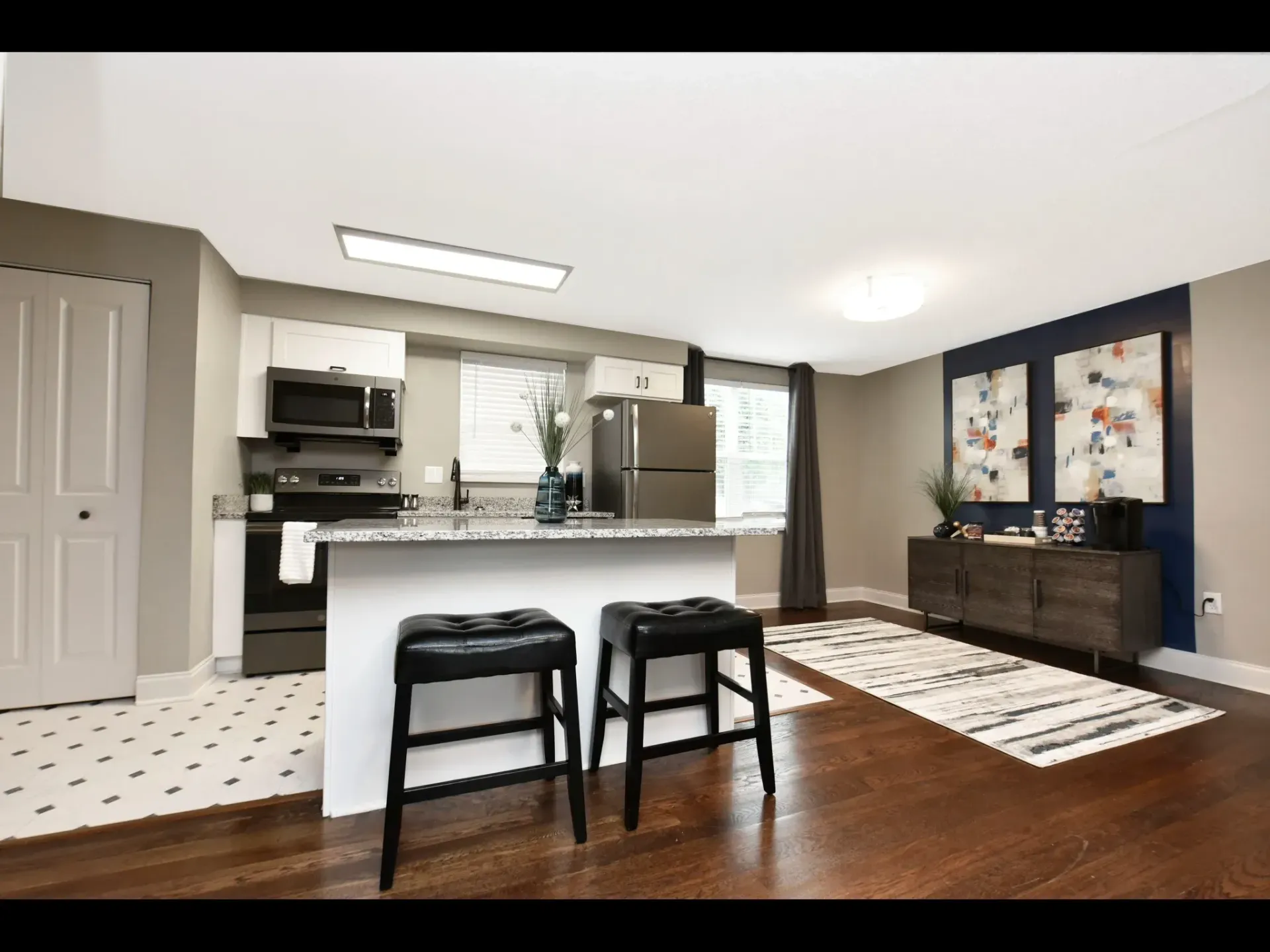 A kitchen with a bar and two stools in it