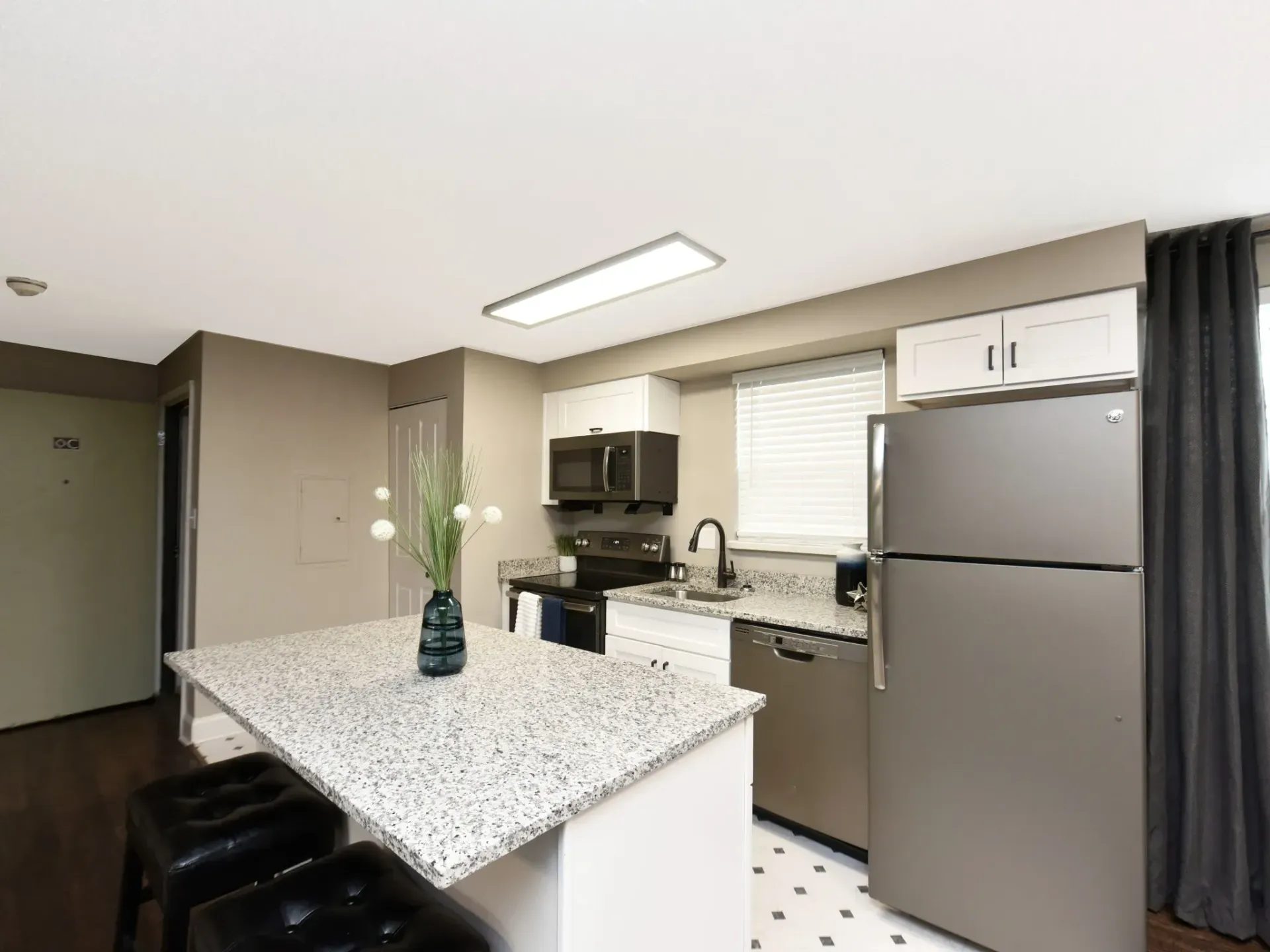 A kitchen with granite counter tops and stainless steel appliances