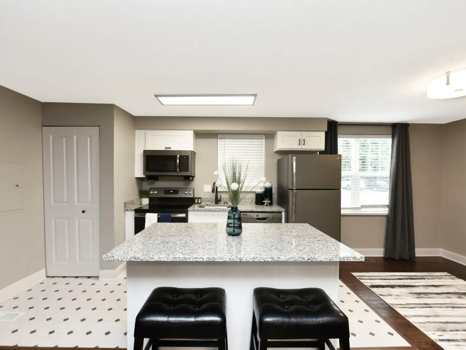 A kitchen with a large island and two stools