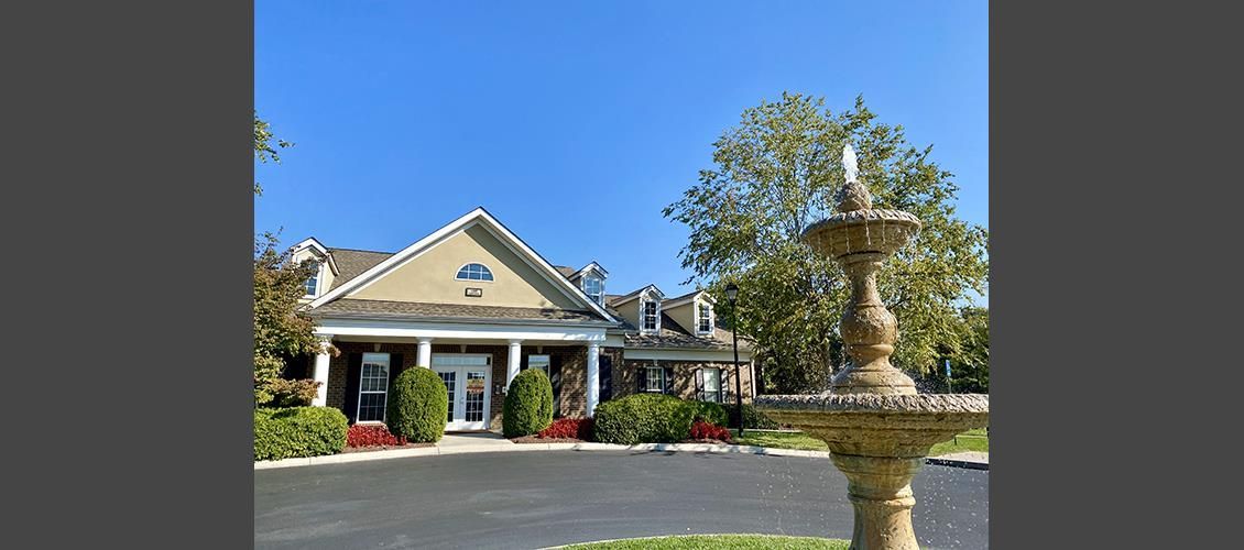 A large house with a fountain in front of it.