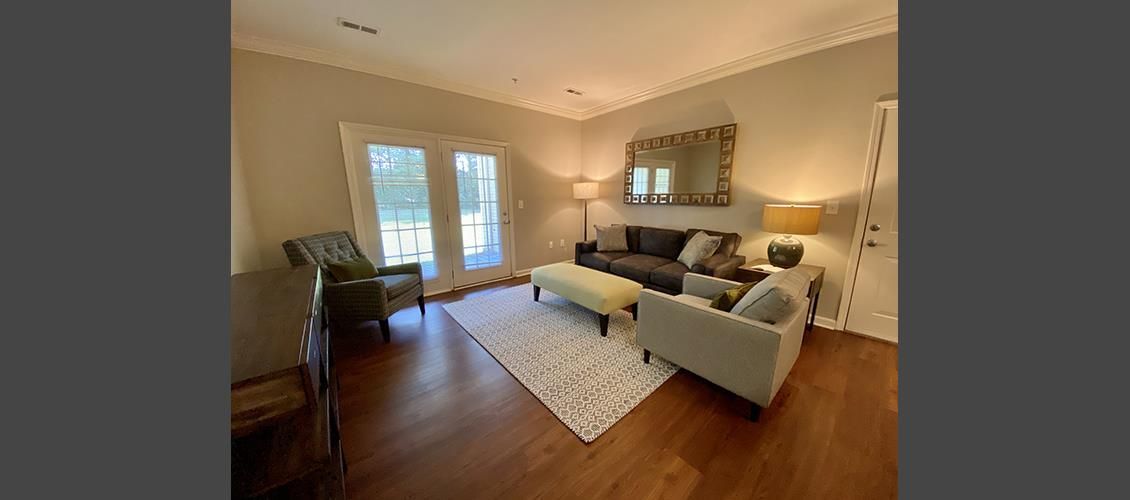 A living room with a couch , chairs , coffee table and sliding glass doors.